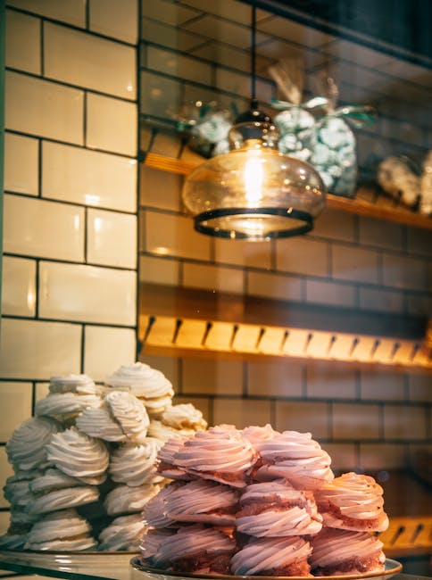 Pink and white meringues displayed in a bakery